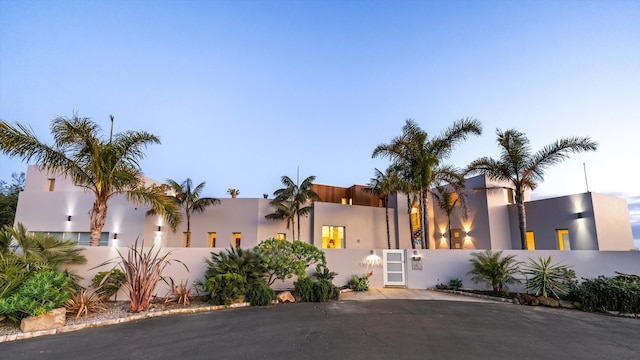 view of front of house with stucco siding and fence private yard