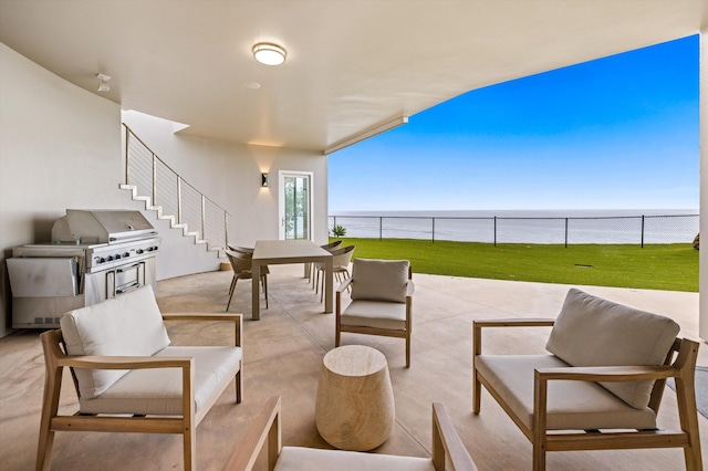 view of patio with stairway, a water view, outdoor dining area, fence, and an outdoor hangout area