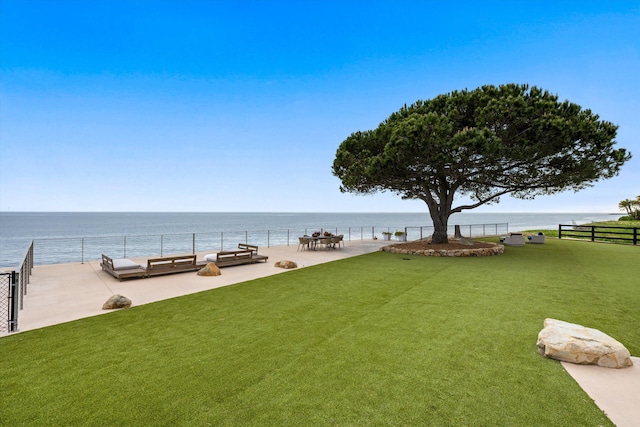 view of home's community featuring fence, a yard, and a water view