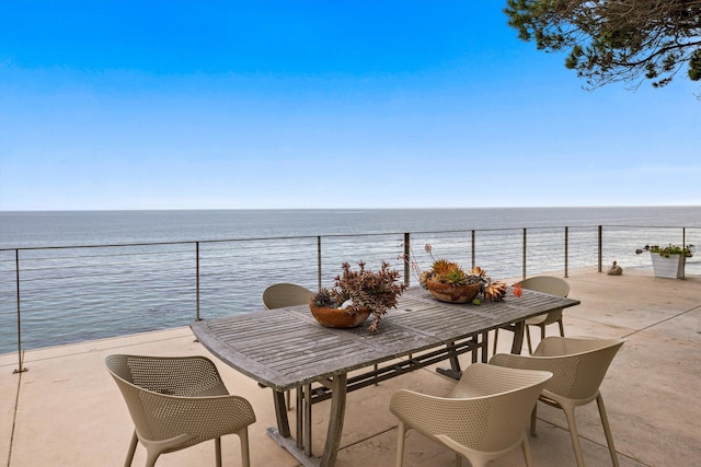 balcony with outdoor dining area and a water view