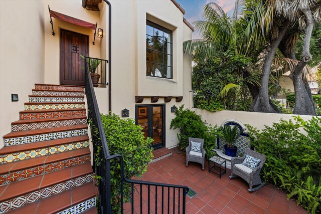 doorway to property with stucco siding, a patio, and french doors
