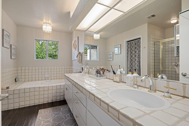 full bath featuring a stall shower, visible vents, a sink, and wood-type flooring