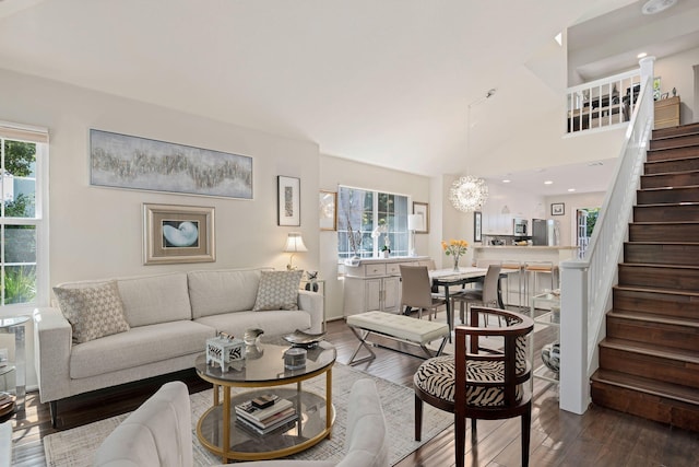 living room featuring a chandelier, wood finished floors, and stairs