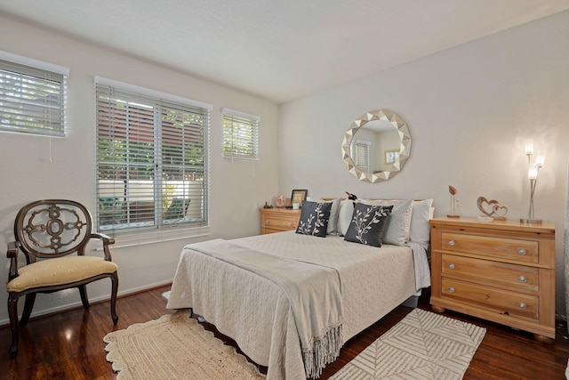 bedroom with baseboards and dark wood-style floors