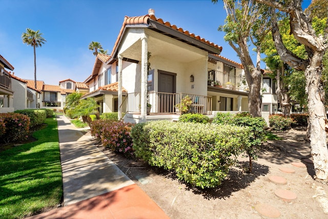 view of front of property featuring a tile roof, a residential view, and stucco siding