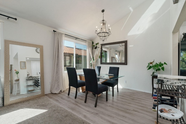 dining room with baseboards, a chandelier, and light wood-style flooring