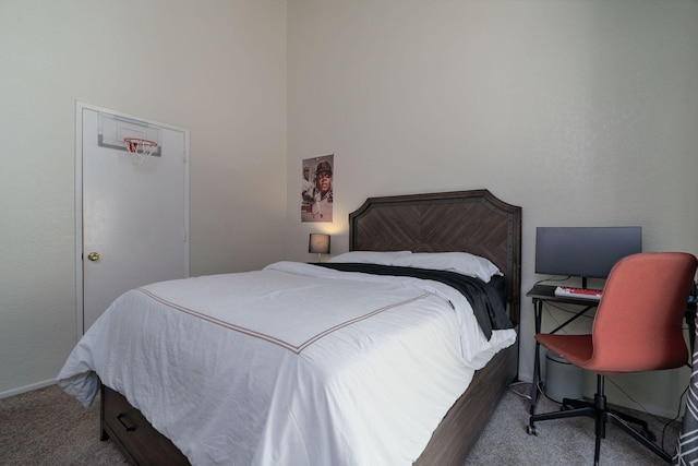 carpeted bedroom featuring a high ceiling and baseboards