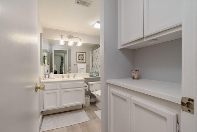 full bath with wood finished floors, visible vents, toilet, and vanity