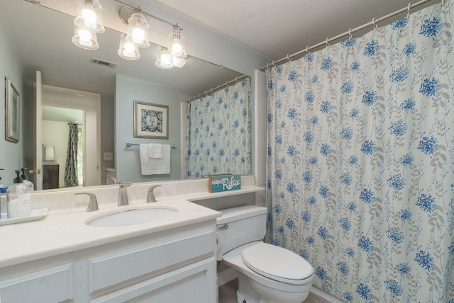 full bath with visible vents, curtained shower, vanity, and toilet