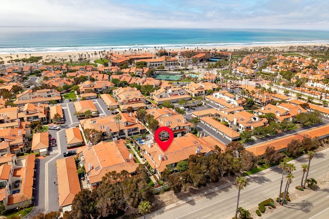 drone / aerial view featuring a residential view, a view of the beach, and a water view