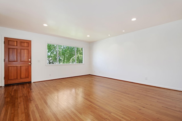 spare room featuring recessed lighting, baseboards, and hardwood / wood-style flooring
