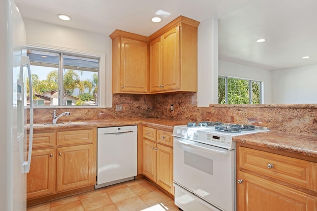 kitchen with a sink, white appliances, light countertops, backsplash, and recessed lighting