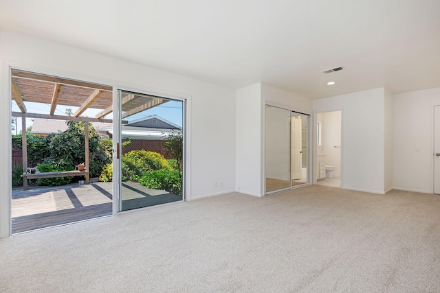 unfurnished bedroom with access to exterior, baseboards, light carpet, and visible vents