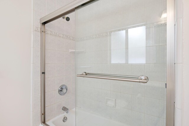 bathroom featuring combined bath / shower with glass door