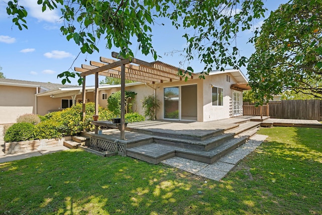 rear view of property with a pergola, a lawn, fence, stucco siding, and a wooden deck