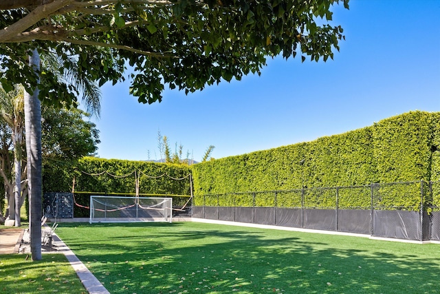 view of home's community with fence and a tennis court