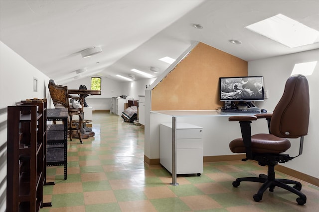 office with baseboards, light floors, and vaulted ceiling with skylight