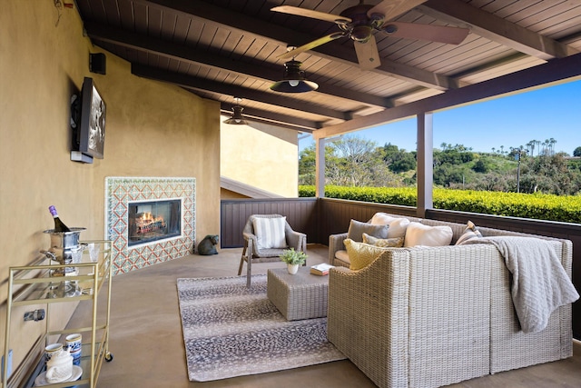 view of patio / terrace featuring a ceiling fan and an outdoor living space with a fireplace
