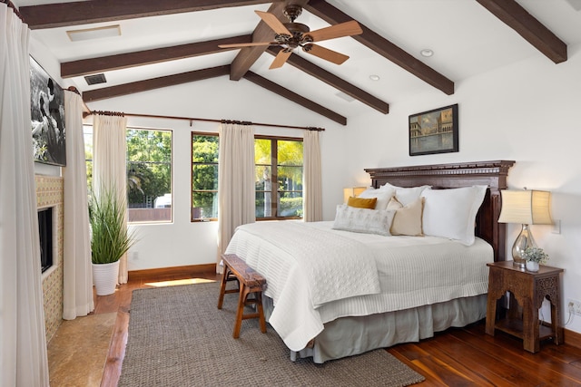 bedroom featuring visible vents, a high end fireplace, wood finished floors, and vaulted ceiling with beams