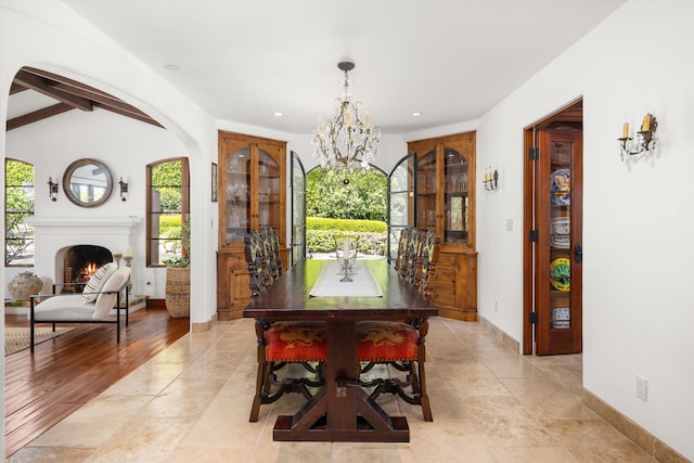 dining space with baseboards, recessed lighting, vaulted ceiling with beams, arched walkways, and a notable chandelier