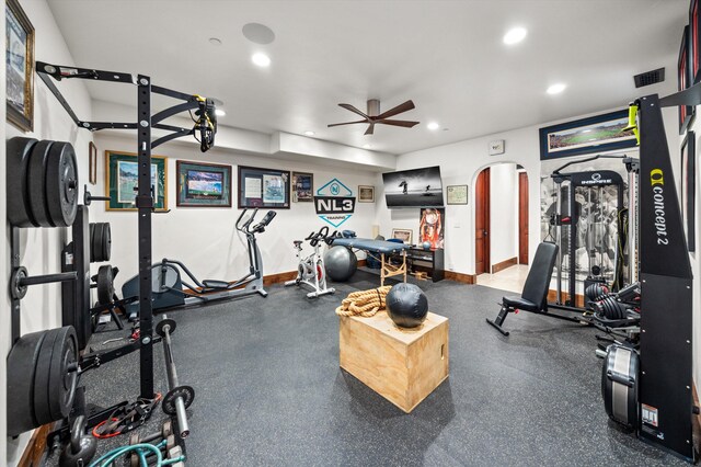 exercise room featuring visible vents, baseboards, recessed lighting, arched walkways, and a ceiling fan