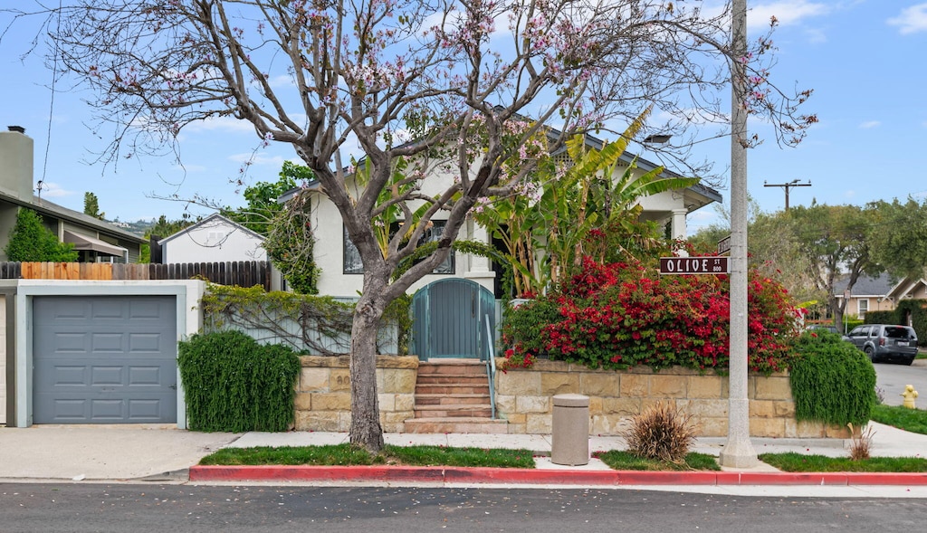 view of front of home with driveway, a garage, and fence private yard