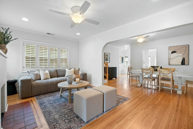 living room featuring light wood-type flooring, arched walkways, recessed lighting, and ceiling fan