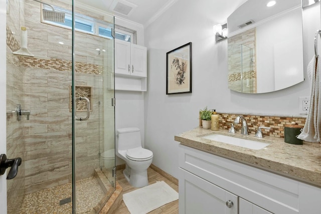 bathroom with a stall shower, visible vents, ornamental molding, and toilet