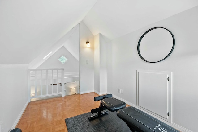 workout room featuring vaulted ceiling and baseboards