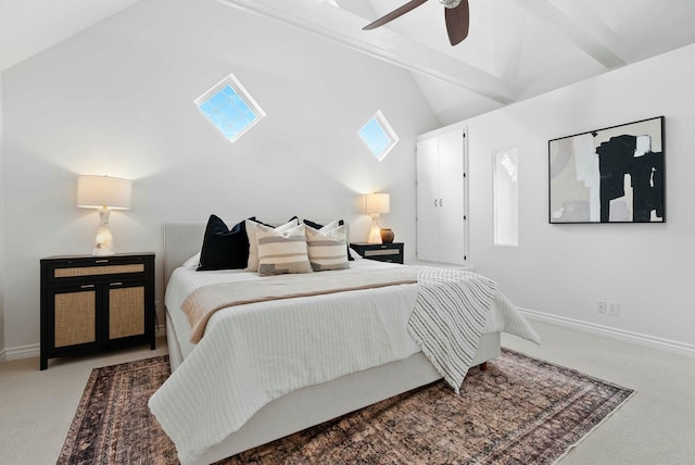 carpeted bedroom with lofted ceiling with skylight, baseboards, and ceiling fan