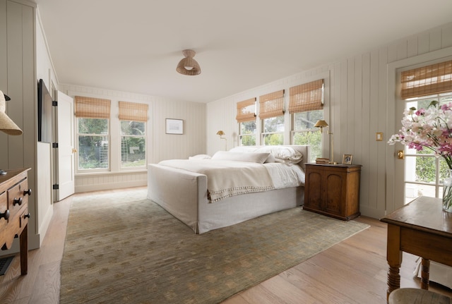 bedroom with multiple windows and light wood-style flooring