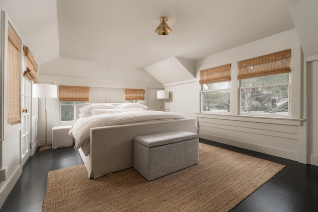 bedroom featuring dark wood-style floors and vaulted ceiling