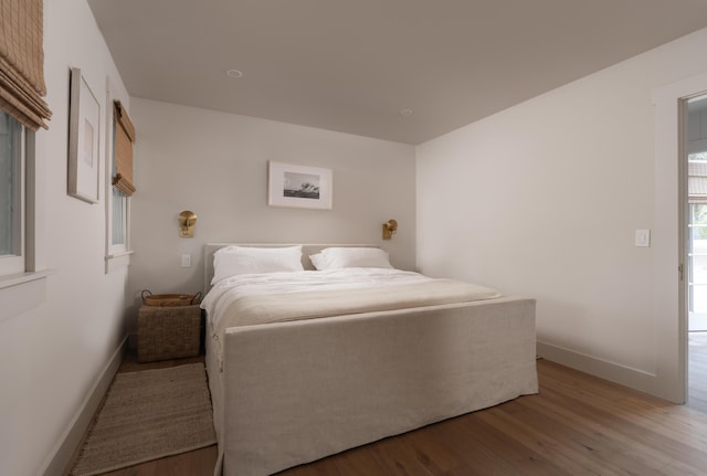 bedroom featuring light wood finished floors and baseboards