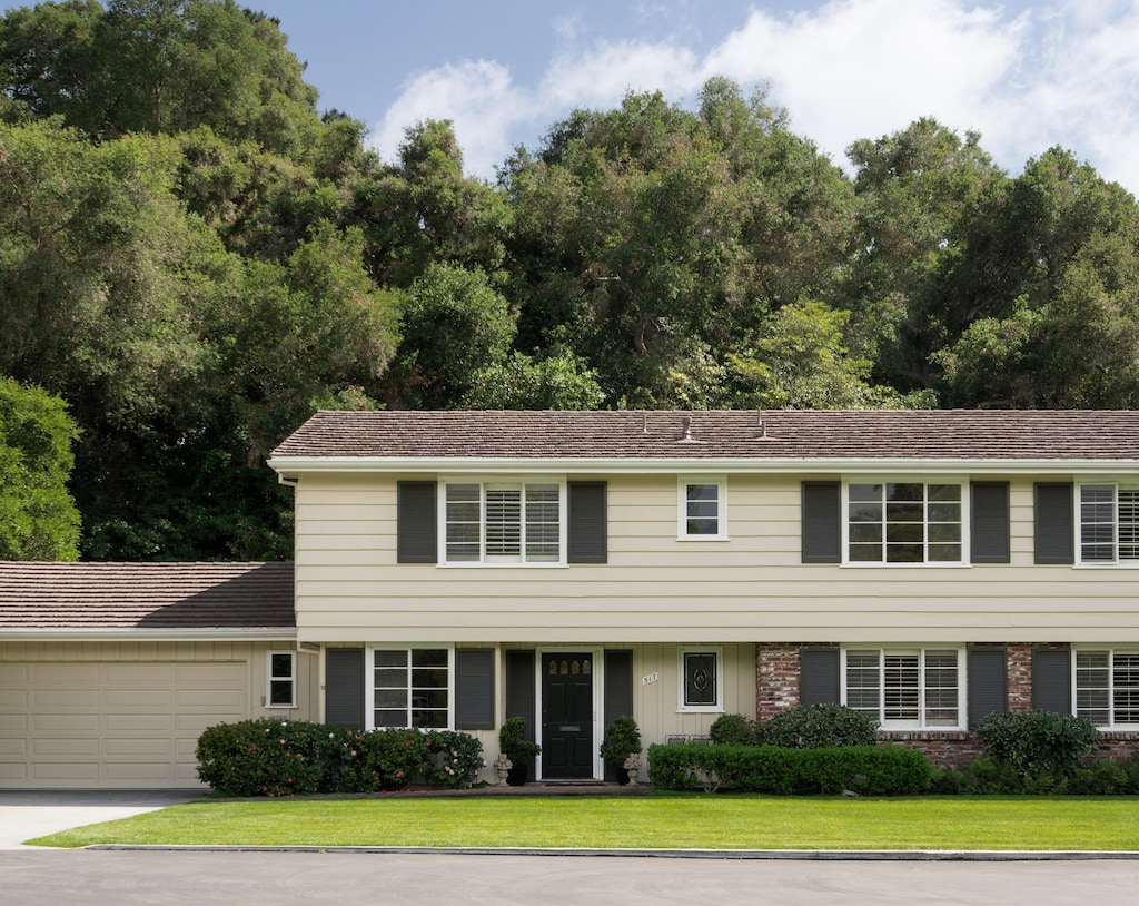 view of front of property with an attached garage, a front yard, and concrete driveway