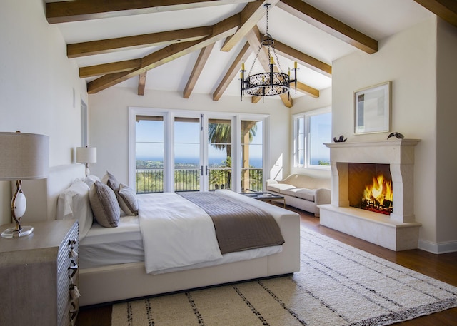 bedroom with an inviting chandelier, a fireplace, baseboards, vaulted ceiling with beams, and wood finished floors
