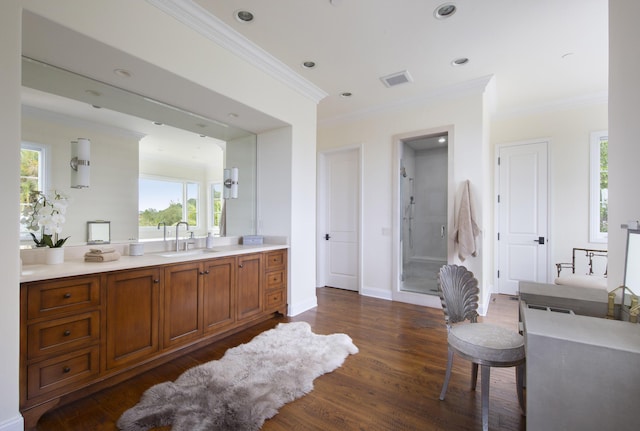 bathroom with vanity, ornamental molding, a stall shower, and wood finished floors