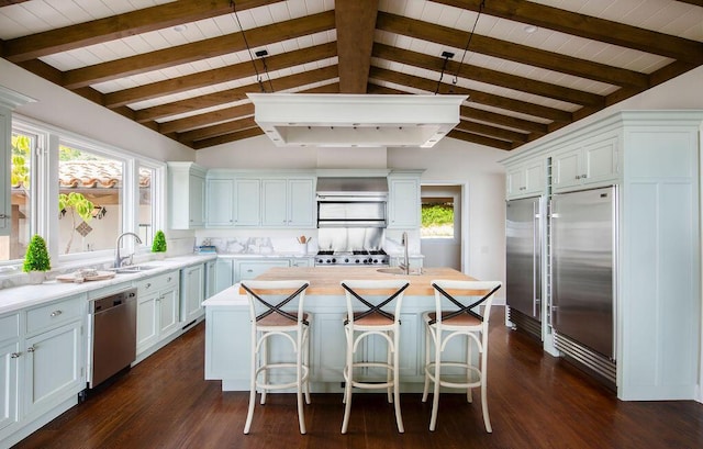 kitchen featuring wood ceiling, appliances with stainless steel finishes, and a sink