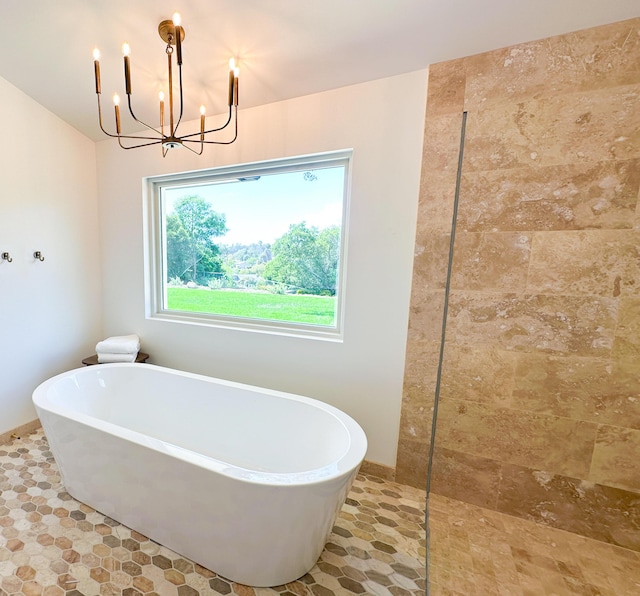 full bath featuring walk in shower, a freestanding tub, and a notable chandelier