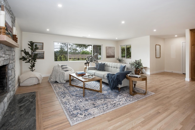living room with a fireplace, light wood-type flooring, baseboards, and recessed lighting