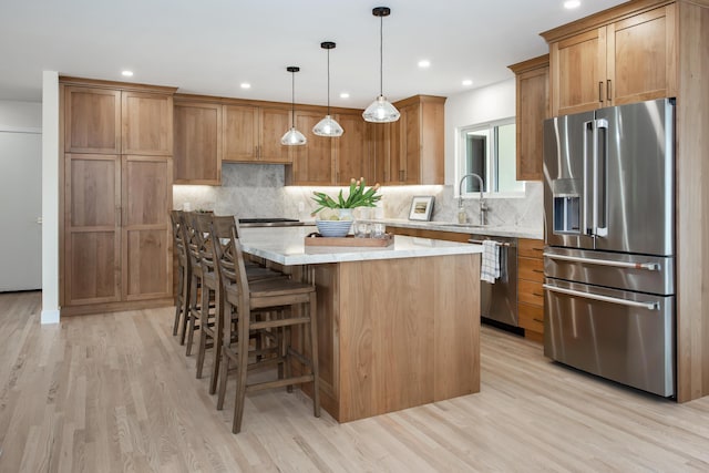 kitchen featuring stainless steel appliances, a center island, recessed lighting, and light wood-style floors