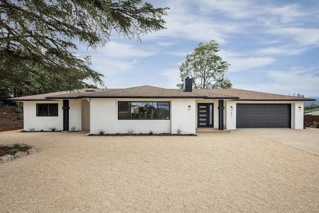 single story home featuring stucco siding, an attached garage, a chimney, and concrete driveway