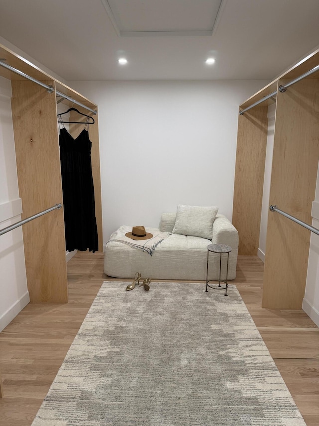 walk in closet featuring attic access and light wood finished floors