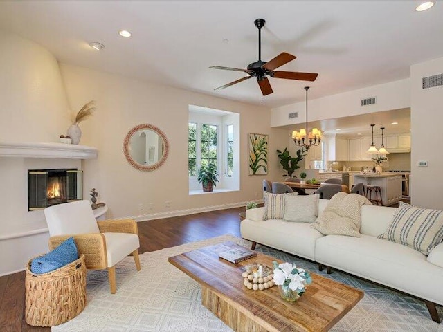 living room featuring ceiling fan with notable chandelier, wood finished floors, visible vents, and recessed lighting