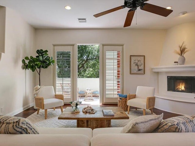living area featuring visible vents, recessed lighting, a ceiling fan, wood finished floors, and a large fireplace