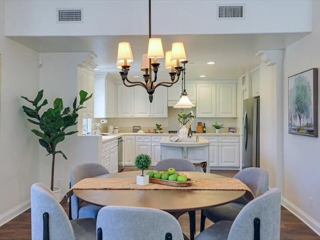 dining area featuring dark wood finished floors, baseboards, visible vents, and an inviting chandelier