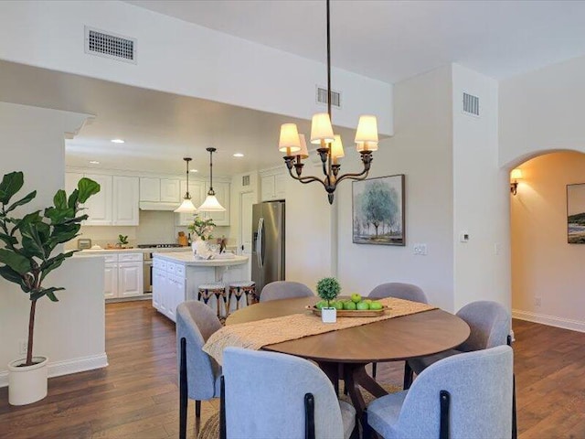 dining area with visible vents, arched walkways, and dark wood finished floors