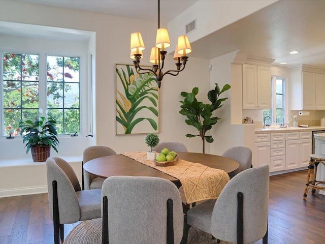 dining area featuring a wealth of natural light, a notable chandelier, and dark wood-type flooring