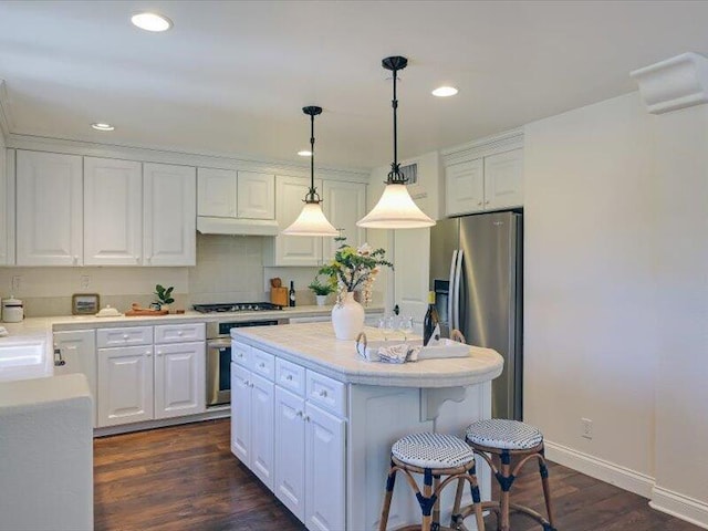 kitchen featuring white cabinets, appliances with stainless steel finishes, a center island, and light countertops