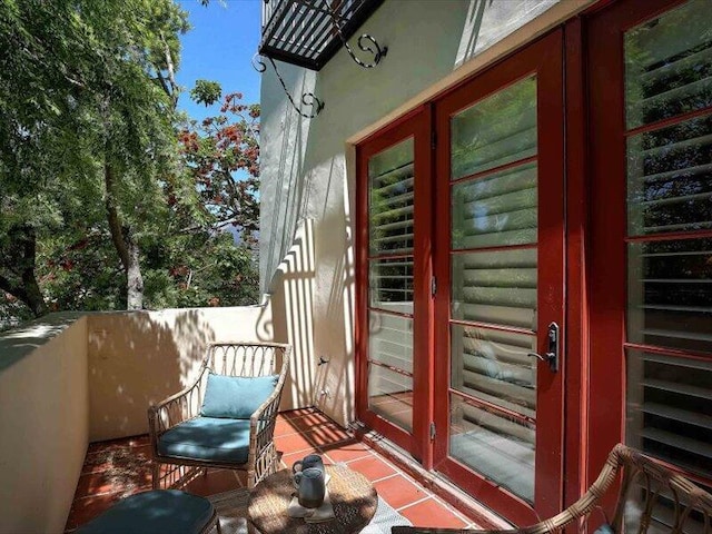 view of exterior entry featuring stucco siding and a balcony
