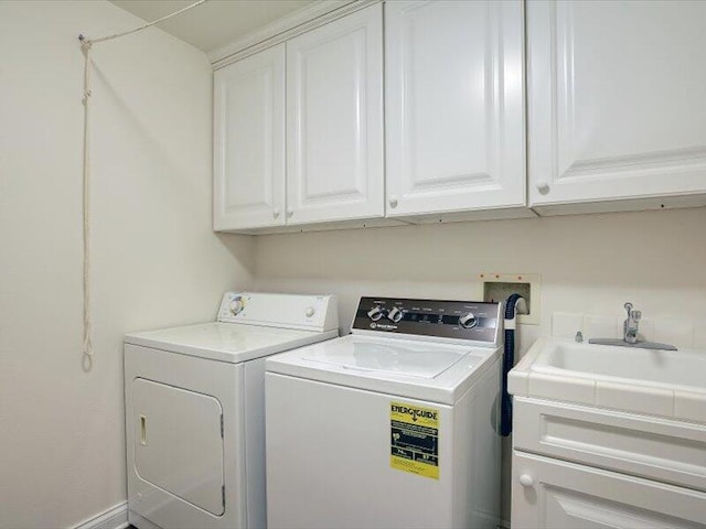 laundry area featuring washing machine and dryer, a sink, and cabinet space